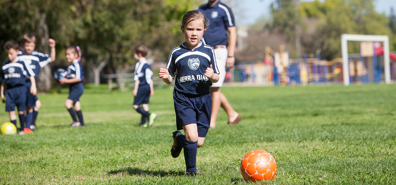 Sierra Oaks girl player running with coaches and players in the background